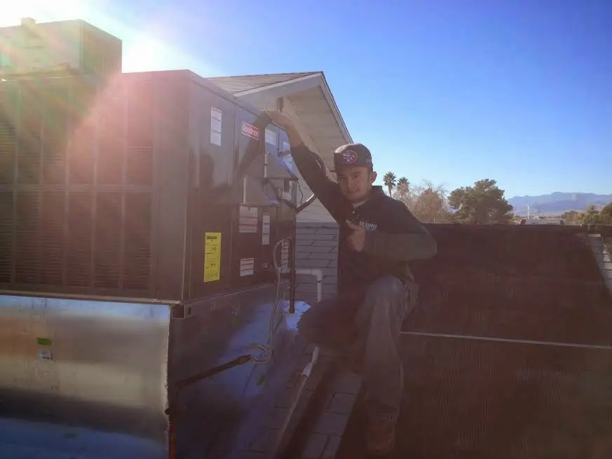 HVAC technician performing Air Duct Cleaning on a rooftop unit in Gonzalez